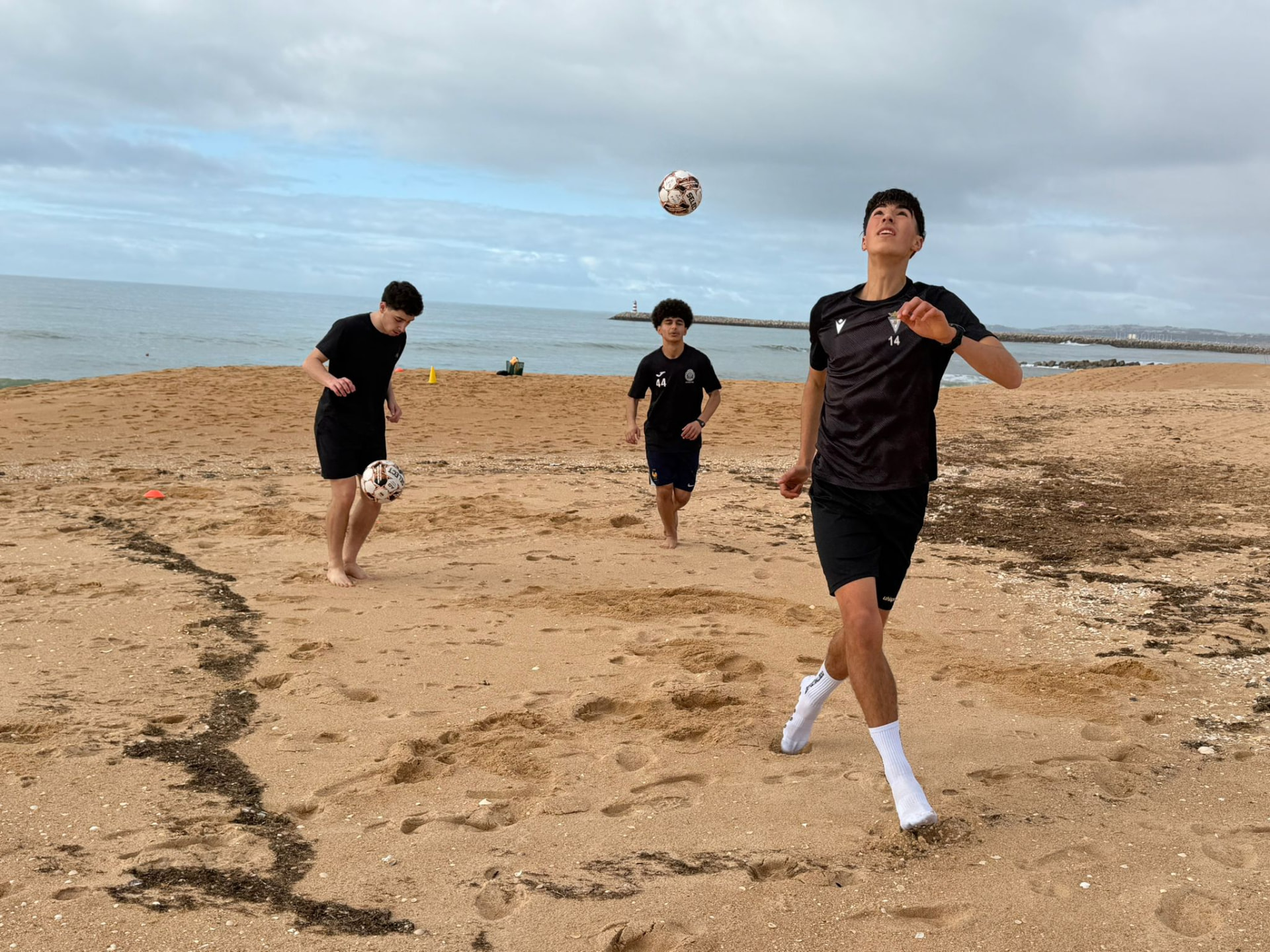 Spelers trainen op het strand tijdens een internationale voetbalervaring
